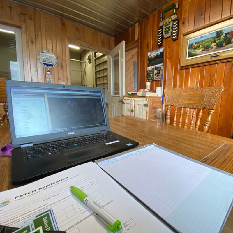 Laptop on table next to worksheet and notepad